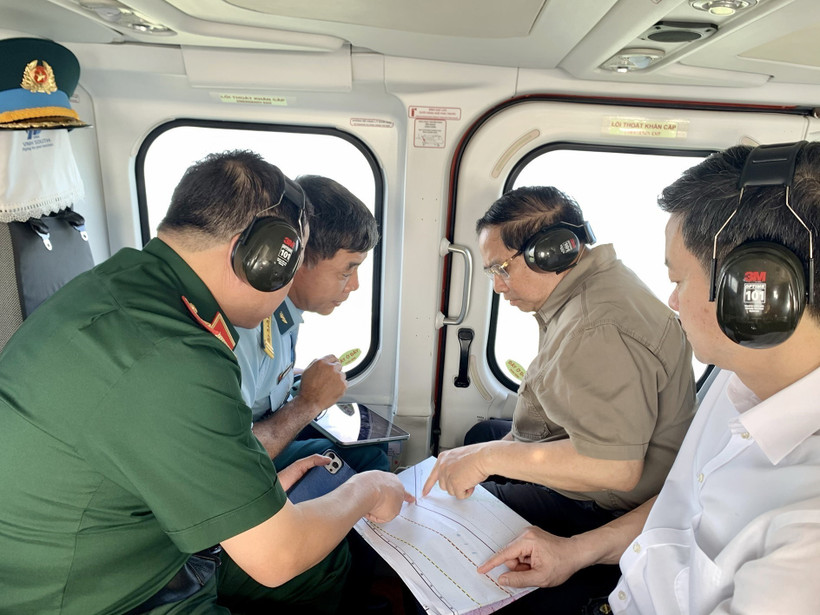 El primer ministro Pham Minh Chinh (segundo desde la derecha) realiza una inspección aérea desde un helicóptero de la autopista Ca Mau-Dat Mui, la carretera que conduce a Hon Khoai y el puerto de doble uso de Hon Khoai. (Foto: VNA) 