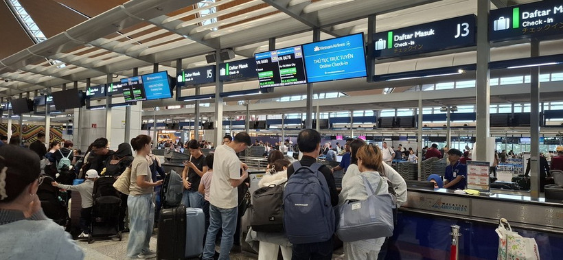 Los pasajeros realizan el check-in en el mostrador de Vietnam Airlines en el Aeropuerto Internacional de Kuala Lumpur. (Foto: VNA)