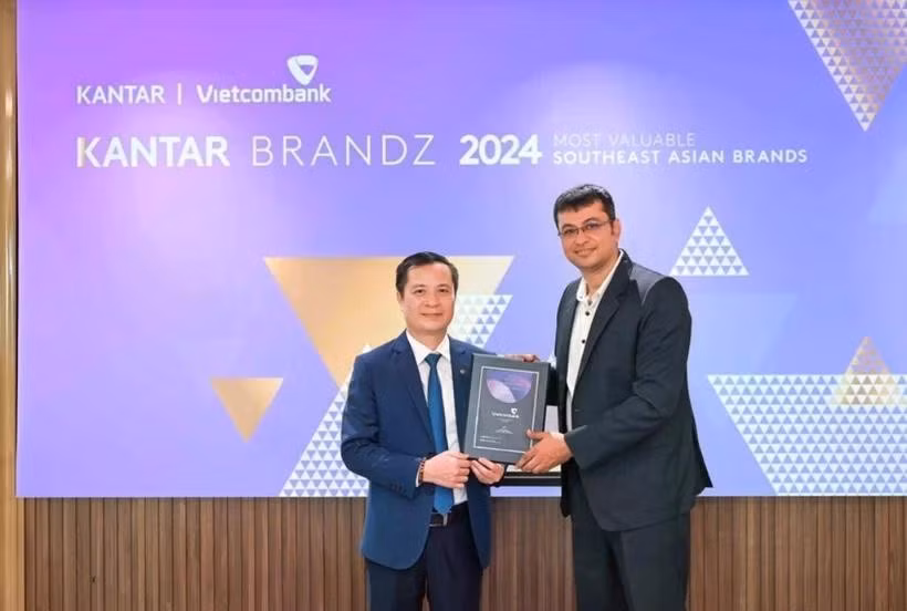 Le Hoang Tung, subdirector general de Vietcombank (izquierda), recibe el certificado de Sumit Kamra, director de desarrollo estratégico de Kantar Insights. (Foto: VNA)