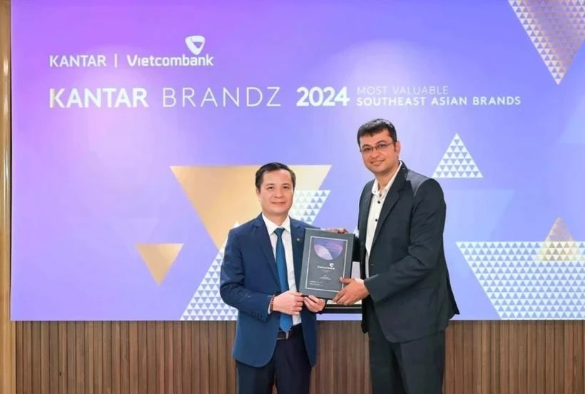 Le Hoang Tung, subdirector general de Vietcombank (izquierda), recibe el certificado de Sumit Kamra, director de desarrollo estratégico de Kantar Insights. (Foto: VNA)