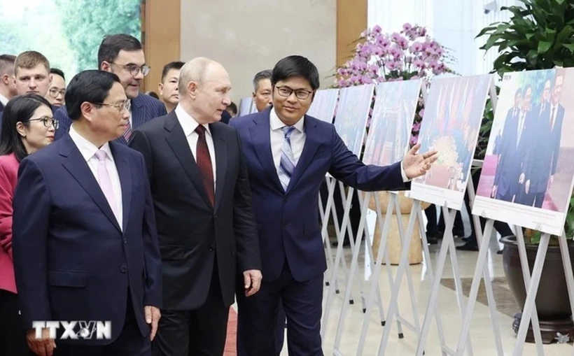 El primer ministro de Vietnam, Pham Minh Chinh (izquierda), y el presidente ruso, Vladimir Putin (centro), visitan una exposición fotográfica sobre la cooperación entre los dos países. (Foto: VNA)