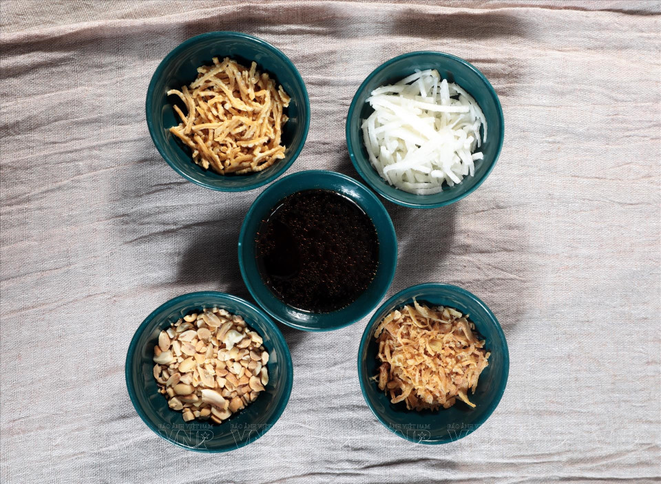 Para elaborar el plato se mezclan los ingredientes como cacahuetes, charlotas fritas crujientes, salsa de soja y aceite de sésamo. (Foto: VNA)