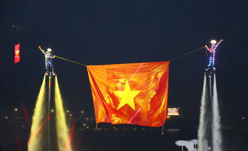 Los atletas de flyboard izan y exhiben la bandera nacional vietnamita sobre el río Dong Nai. (Foto: VNA)