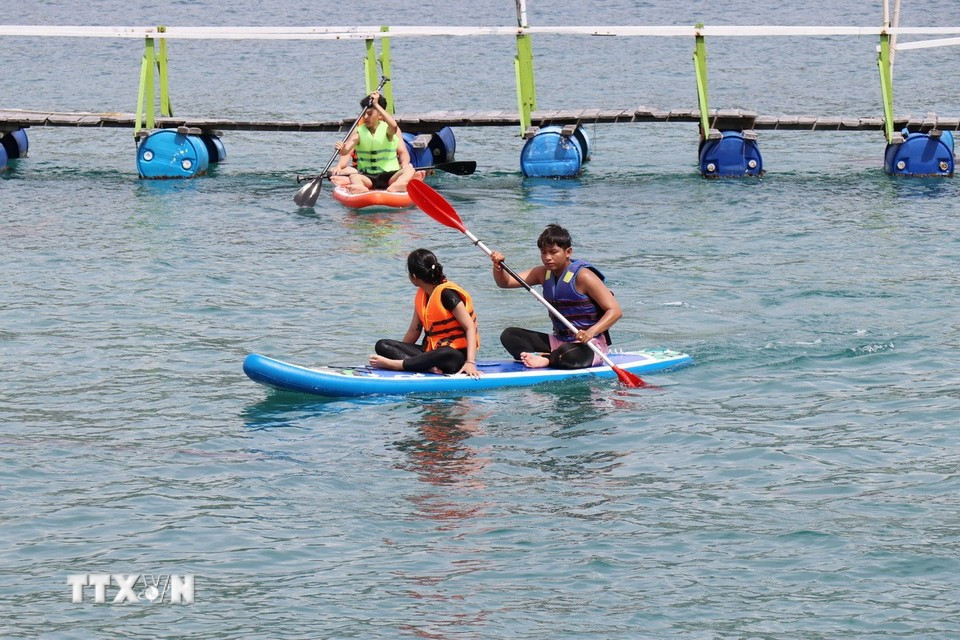 Turistas reman en kayak en la bahía de Vinh Hy, comuna de Vinh Hai, provincia de Khanh Hoa. (Foto: VNA)