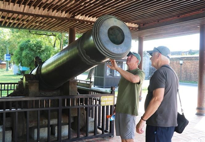 Turistas extranjeros aprecian un cañón en la Ciudadela Imperial de Hue. (Foto: VNA)