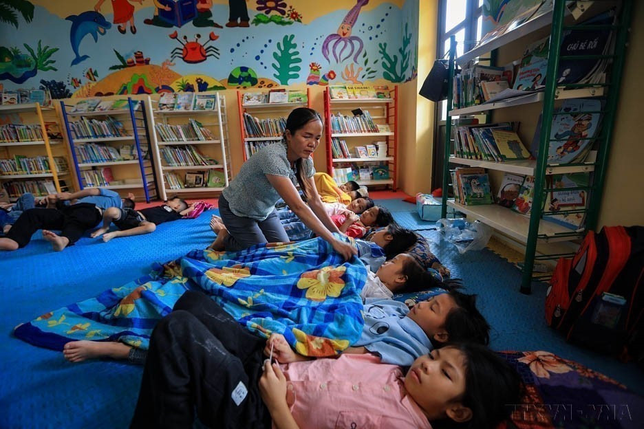 Vietnam trabaja por mejorar la calidad de la población a través de políticas centradas en los derechos humanos de manera humanitaria y práctica. En la foto: Una maestra atiende a los estudiantes en la escuela. (Foto: VNA)