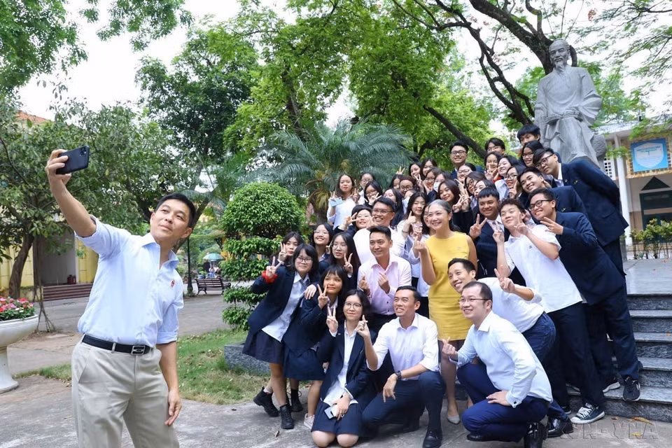 El presidente del Parlamento de Singapur, Tan Chuan-Jin, se tomó una selfie con los estudiantes frente a la estatua del maestro Chu Van An en el patio de la homónima escuela preuniversitaria en Hanoi (19 de mayo de 2022). (Foto: VNA)