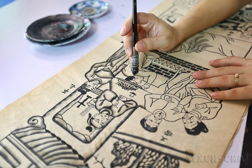 Dibujar las pinturas Dong Ho requiere mucho tiempo. Primero se debe seleccionar el tema, el mensaje, el contenido y colores armoniosos para lograr una composición razonable y un alto valor artístico. (Foto: VNA)