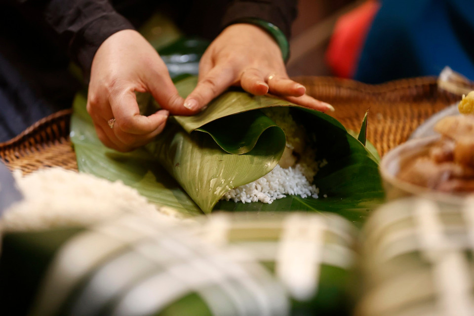 Se requiere de un par de manos habilidosas para envolver hermosos pasteles cuadrados en preparación para la tradicional festividad del Tet. (Foto: VNA)