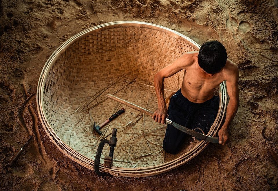 Para dar forma al barco se excava un agujero redondo en la tierra, donde se coloca la base de bambú tejido para su posterior modelado. (Foto: VNA)
