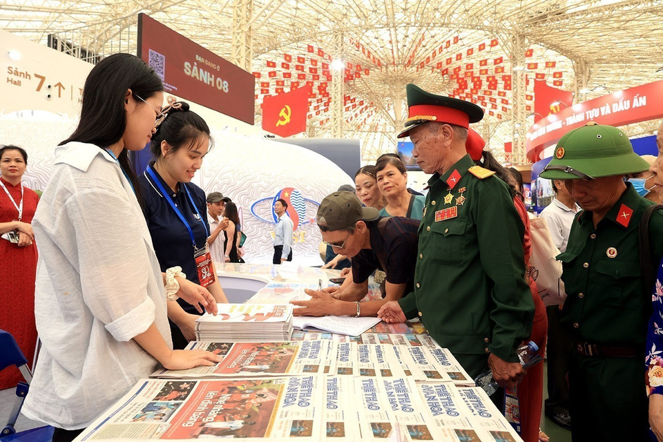Reparten periódicos gratuitos en el stand de la Agencia Vietnamita de Noticias. (Foto: VNA)