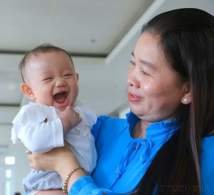 Una mujer en la provincia de Hau Giang recibe certificado de mérito para una familia destacada con dos hijas (5 de enero de 2023). (Foto: VNA)