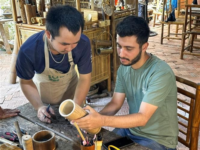 Turistas foráneos experimentan la elaboración de artesanías en la ciudad de Da Nang. (Foto: VNA)