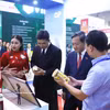 El embajador de Vietnam en Laos, Nguyen Minh Tam y el viceministro de Industria y Comercio de Laos, Phouthavanh Nanthavong visitan un stand vietnamita en la feria (Foto: VNA)