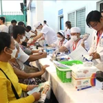 El personal médico realizan chequeos a las personas que participan en el programa. (Foto: VNA)