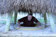 El turista se sitúa en una entrada de túnel ubicada en el jardín de una vivienda en el túnel de Ky Anh. (Fuente: VNA)