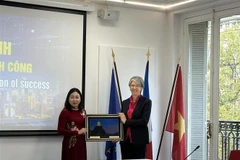 La vicesecretaria permanente del Comité del Partido de Ninh Binh, Dinh Thi Lua, entrega regalo a Géraldine Lemblé, subdirectora general de MEDEF. (Fuente: VNA)