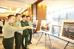 Delegados chinos visitan una exposición fotográfica del desfile militar que celebra el 80 aniversario del Día Nacional de Vietnam. (Fuente: VNA)