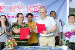 Thi Khui, directora de a Cooperativa Agrícola de Anacardo Orgánico Trang Co Bu Lach, firma un acuerdo de cooperación un representante de la empresa Intersnack Vietnam. (Fuente: Periódico Dong Nai) 