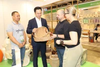Clientes internacionales aprenden sobre los productos artesanales vietnamitas. (Fuente: VNA)