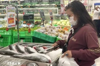 Los consumidores eligen productos del mar en un supermercado. (Foto: VNA)