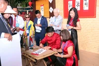 Vietnamitas en el extranjero hacen fila para pedir caligrafía. (Fuente: VNA)