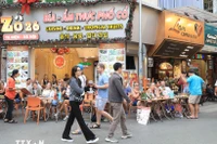 Turistas extranjeros disfrutan de la gastronomía en la calle Ta Hien, Hanoi. (Foto: VNA)