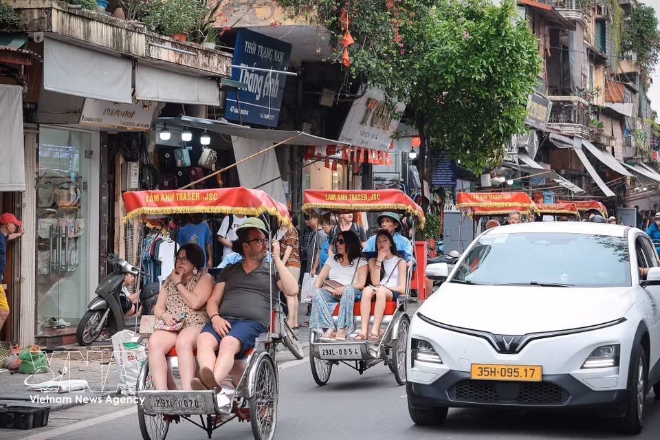 Los visitantes exploran el Casco Antiguo de Hanoi en triciclo, disfrutando de la arquitectura distintiva de la capital y su vibrante vida callejera. (Foto: VNA)