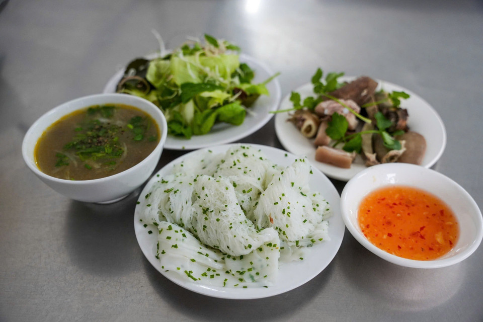 Una buena tanda debe tener hebras tan finas como escarbadientes de bambú, los trozos no deben estar separados ni apelmazados, no deben desmenuzarse al comer, y se debe poder saborear la dulzura de la harina de arroz y la riqueza del aceite de coco. Se sirve con vísceras de cerdo, como corazón, hígado, riñones, etc., acompañadas de hierbas y salsa de pescado con tamarindo. (Foto: VNA)