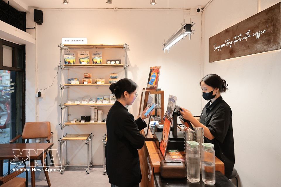 Una clienta escanea el código QR para realizar su pago en un café. (Foto: VNA)