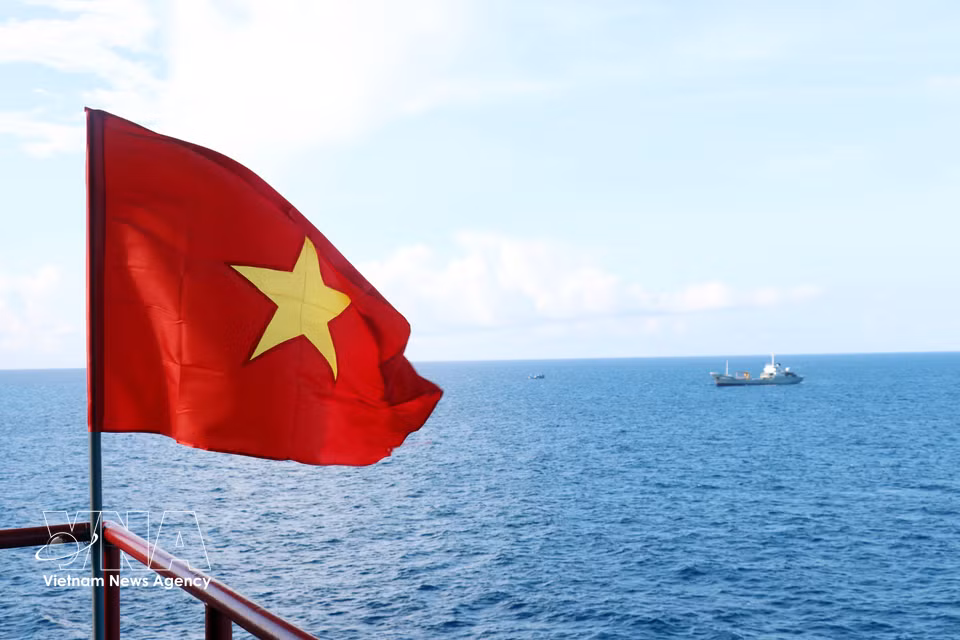 La bandera nacional ondea sobre la Estación de Servicios Económicos, Científicos y Técnicos de Que Duong, en la plataforma DK1/8. (Foto: VNA)