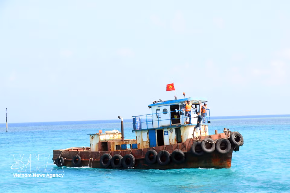 La bandera de Vietnam ondea en un remolcador cerca del muelle de la isla Da Lon B, en un entorno marítimo estratégico. (Foto: VNA)