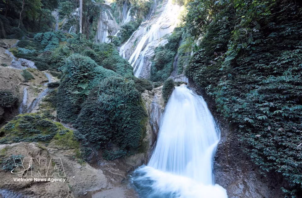 A ambos lados de la cascada crece una vegetación abundante y diversa, que realza aún más el atractivo natural del lugar. (Foto: VNA)