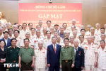 El secretario general del Partido Comunista de Vietnam, To Lam (quinto de derecha de primera fila) recibe a oficiales de policía que apoyaron el campo de batalla en el Sur durante la guerra