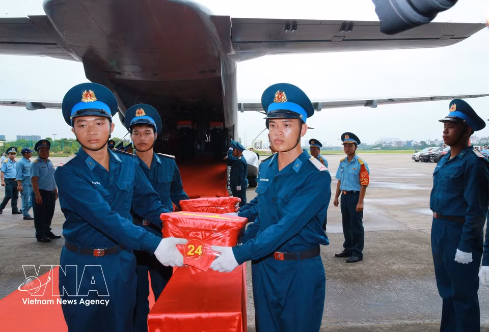 Ceremonia solemne de traslado de las muestras de restos óseos de los mártires desde el avión, en el aeropuerto de Gia Lam, para la posterior ofrenda de incienso en su memoria. Foto: VNA