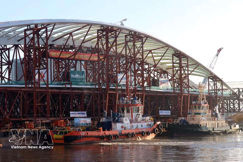 Los remolcadores maniobran progresivamente para colocar el tramo del puente en su posición de montaje, entre las dos secciones ya construidas. Foto: VNA