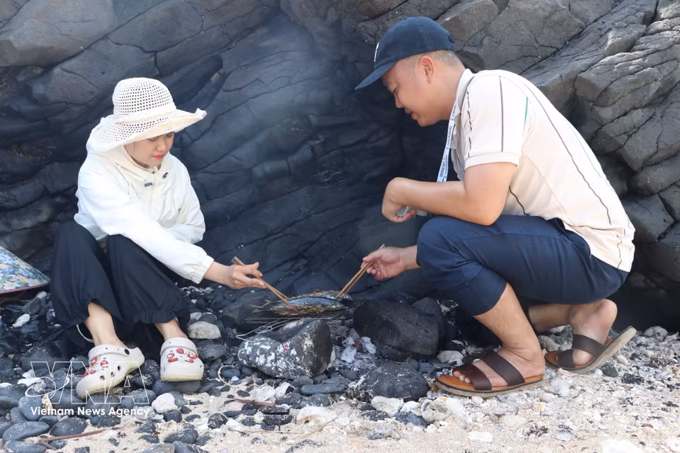 Los visitantes pueden disfrutar de la experiencia de asar pescado durante su estancia en Hon Nhan. (Fuente: VNA)