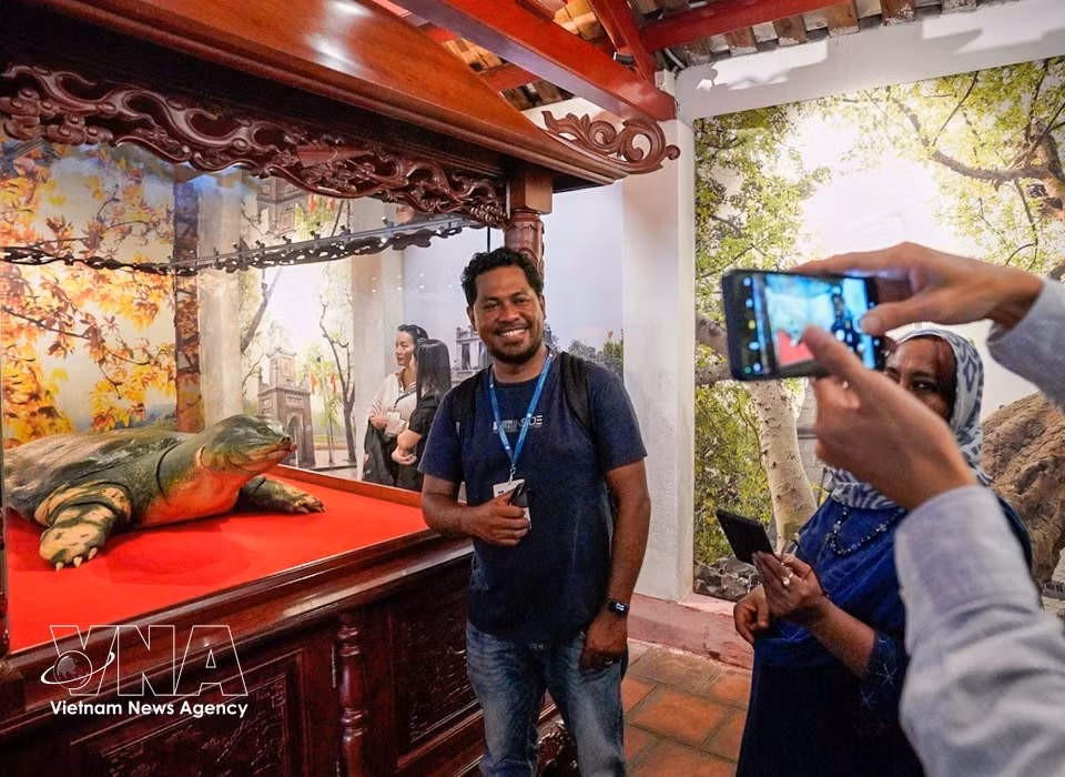 Los delegados visitan y conocen el sitio histórico del templo de Ngoc Son. Foto: VNA