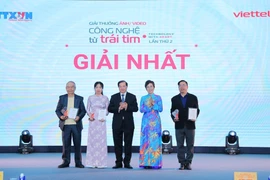La directora general de la VNA y presidenta del Consejo del Premio, Vu Viet Trang, y el viceministro de Cultura, Deportes y Turismo, Ta Quang Dong, entregan el primer premio a los autores. (Foto: VNA)