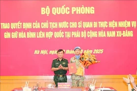 El miembro del Comité Central del Partido Comunista de Vietnam y viceministro de Defensa, teniente general Hoang Xuan Chien, entrega la decisión del Presidente de la República al oficial designado a una misión de mantenimiento de la paz de la Organización de las Naciones Unidas. (Foto: VNA)
