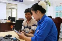Una jóven de la Unión de Jóvenes Comunistas Ho Chi Minh de la comuna de Tuy An Nam, provincia de Dak Lak, orienta a los residentes sobre cómo completar la información correctamente antes de presentar los documentos para trámites administrativos. Foto: VNA