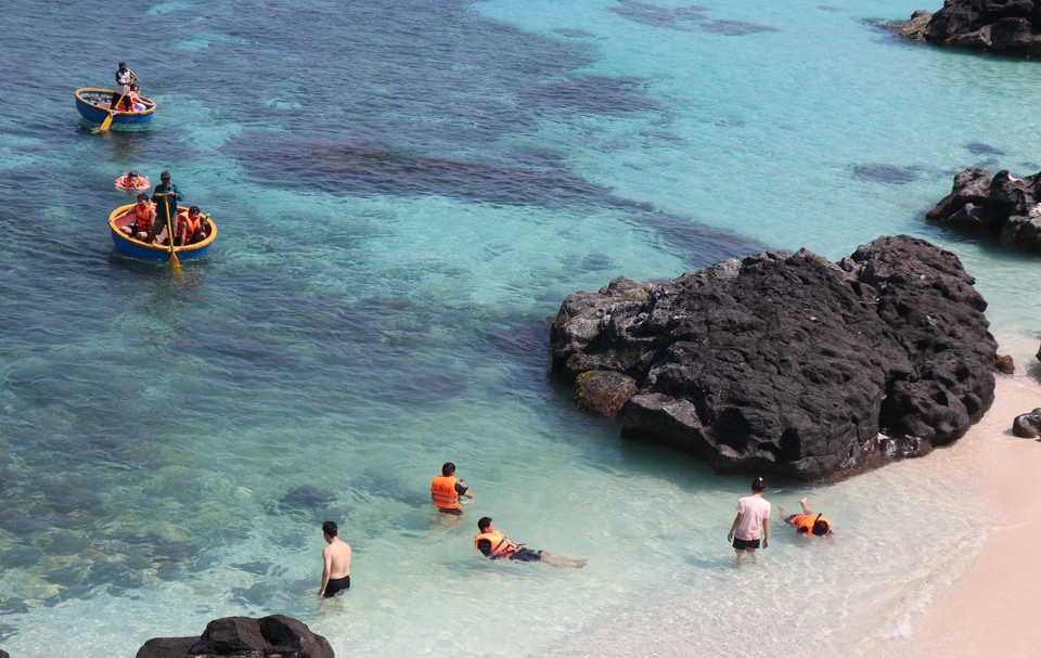 Turistas disfrutan de la experiencia de nadar en canastas flotantes y de sumergirse en las aguas cristalinas de la Isla Be. Foto: VNA