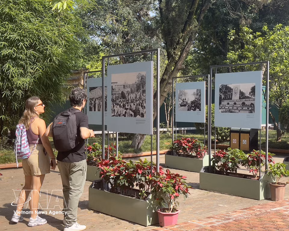 Turistas internacionales recorren la muestra fotográfica “Ecos de un nuevo día” en la Ciudadela Imperial de Thang Long. (Foto: VNA)