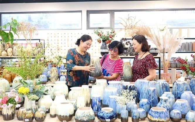 La artesana Ha Thi Vinh (a la izquierda), presidenta de la Asociación de Artesanía y Oficios de Hanoi y directora de la empresa Quang Vinh Cerámica, con más de 30 años de experiencia en la producción de cerámica artística para exportación, un producto OCOP de 5 estrellas a nivel nacional, llevando sus productos al mercado europeo. Actualmente, su empresa emplea a más de 700 personas en dos instalaciones en Bat Trang y Quang Ninh, convirtiéndose en un referente en la industria cerámica de Vietnam. Foto: VNA