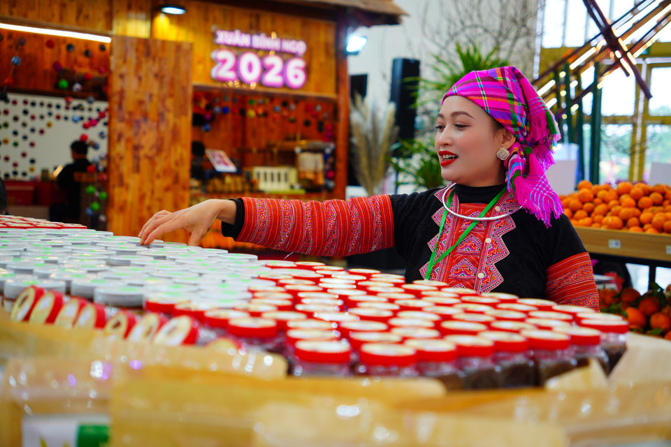 Mujer con indumentaria tradicional de la etnia Mong presentando productos en el stand de la provincia de Son La. (Foto: VNA)