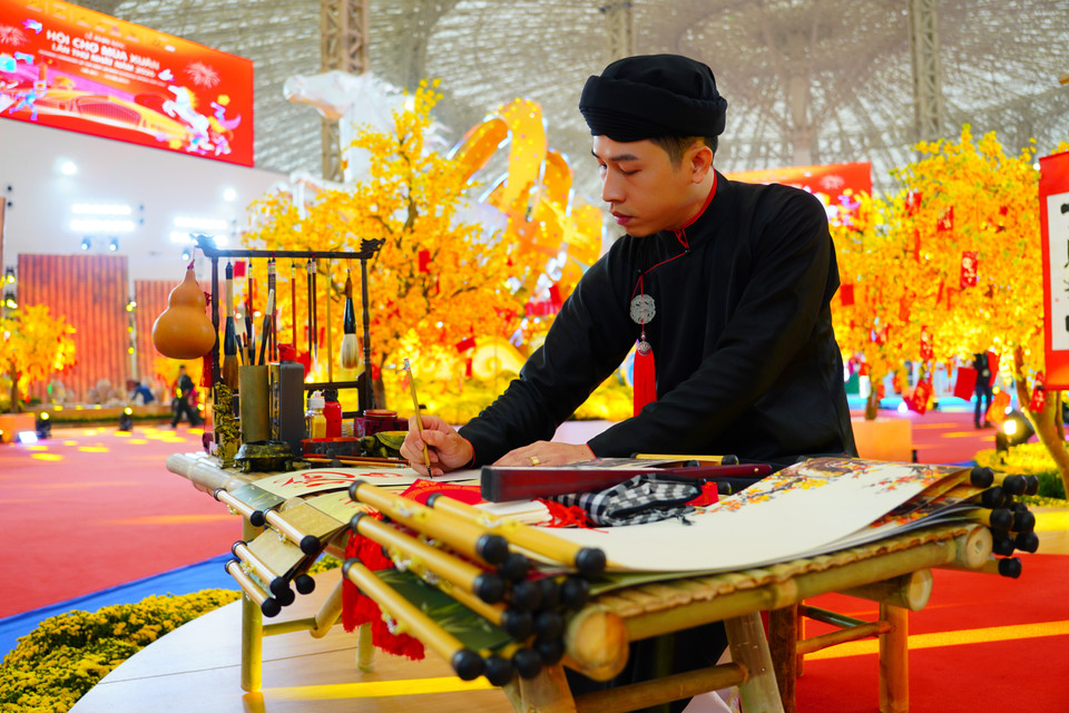 Artesano con túnica tradicional y turbante practicando el arte de la caligrafía. (Foto: VNA)