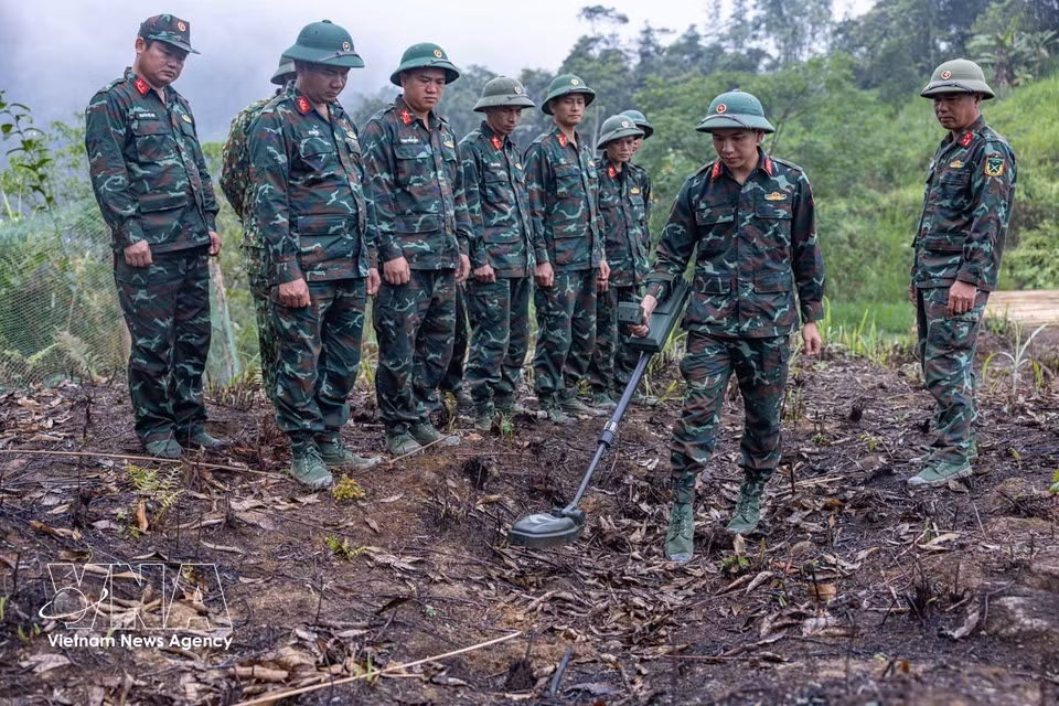 Los miembros del equipo continúan su preparación y uso especializado de detectores de minas para garantizar que el área esté segura antes de iniciar la búsqueda. Foto: VNA