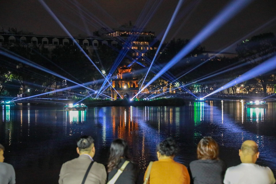 Los visitantes disfrutan de la iluminación artística en el Lago Hoan Kiem y la Torre de la Tortuga. (Foto: VNA)