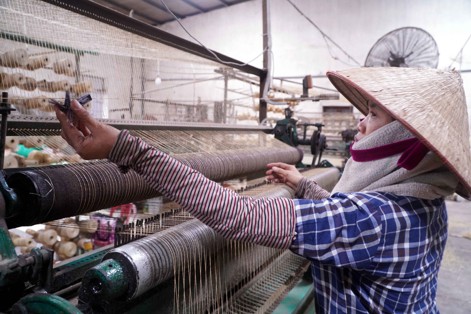 El uso de máquinas ofrece numerosas ventajas: esteras más gruesas y uniformes, y la confección de los bordes es mucho más rápida que en el tejido manual. (Foto: VNA)