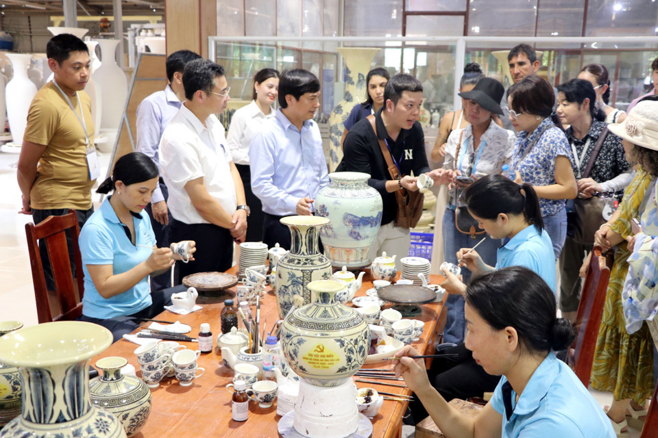 Los visitantes muestran interés en el proceso artesanal de la cerámica Chu Dau. (Foto: VNA)